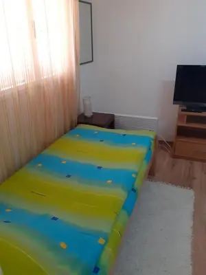 a bed in a room with a yellow and blue at Smestaj Stankovic in Soko Banja