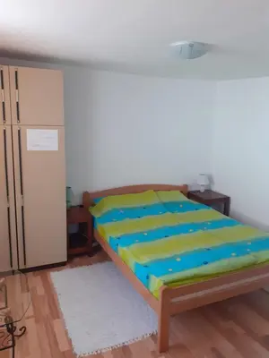 a bedroom with a bed with a blue and green sheets at Smestaj Stankovic in Soko Banja