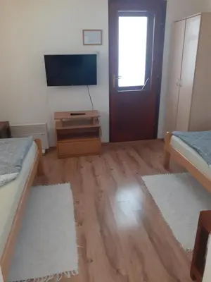 a room with two beds and a flat screen tv at Smestaj Stankovic in Soko Banja