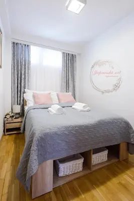 a bedroom with a large bed with two towels on it at Apartman Japanski vrt, Centar in Vrnjačka Banja
