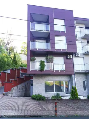 a purple building with stairs on the side of it at Apartman Japanski vrt, Centar in Vrnjačka Banja