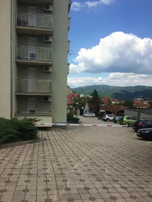 a building with a parking lot in front of it at Apartman Jacka in Vrnjačka Banja