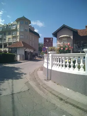 a street with a white fence and a building at Apartman Jacka in Vrnjačka Banja