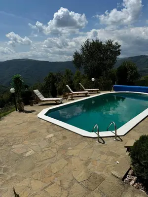 a swimming pool with chairs and a table at Etno selo Milanovic - Nonac in Kuršumlija