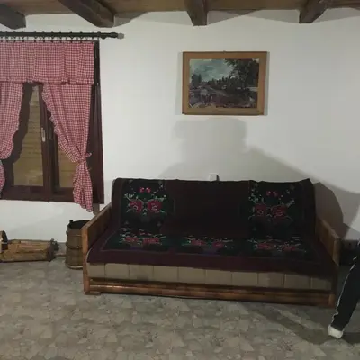 a couch sitting in a room with a window at Etno selo Milanovic - Nonac in Kuršumlija