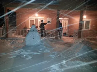 a group of people standing in a house making a snowman at Etno selo Milanovic - Nonac in Kuršumlija