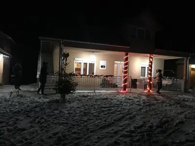 a house with christmas lights in the snow at night at Etno selo Milanovic - Nonac in Kuršumlija