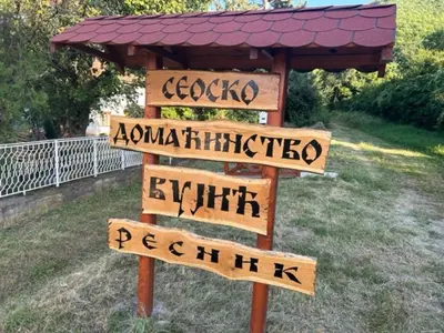 a sign with arrows on it in a yard at Seosko domacinstvo Vujic Sokobanja Resnik in Resnik