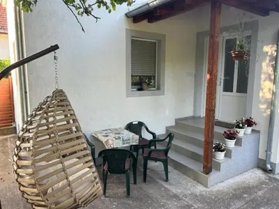 a porch with a hammock and a table and chairs at Seosko domacinstvo Vujic Sokobanja Resnik in Resnik