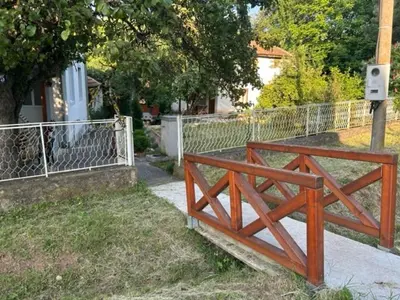 a wooden bridge on a sidewalk next to a fence at Seosko domacinstvo Vujic Sokobanja Resnik in Resnik