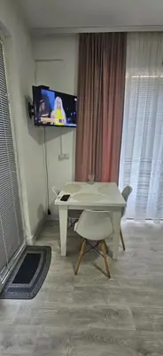 a living room with a white table and a tv at Apartman Casa Lux in Vrnjačka Banja