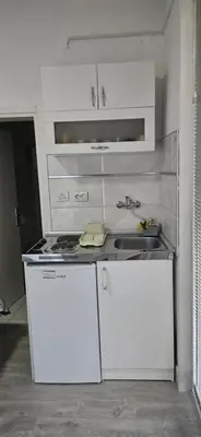 a white kitchen with a stove and a sink at Apartman Casa Lux in Vrnjačka Banja