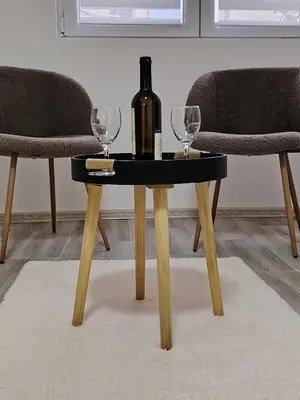 a table with a bottle of wine and two glasses at Relax Apartmani Niš in Niš