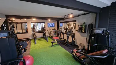 a gym with several treadmills and exercise bikes at City apartment and gym in Niš