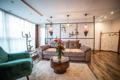 a living room with a couch and a table at City apartment and gym in Niš