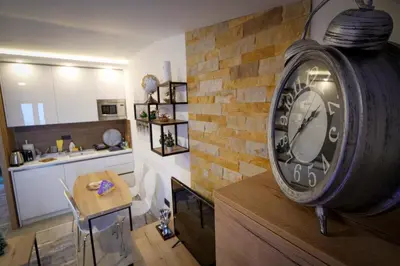 a clock hanging on a brick wall in a kitchen at Mips P86 Milmari Resort in Kopaonik
