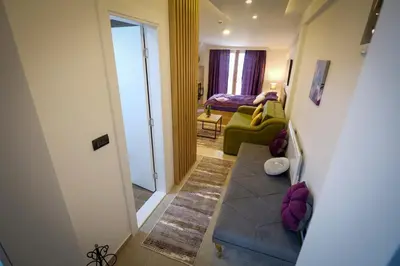 a hallway with a living room with a green couch at Mips P86 Milmari Resort in Kopaonik