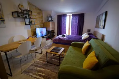 a living room with a green couch and a table at Mips P86 Milmari Resort in Kopaonik
