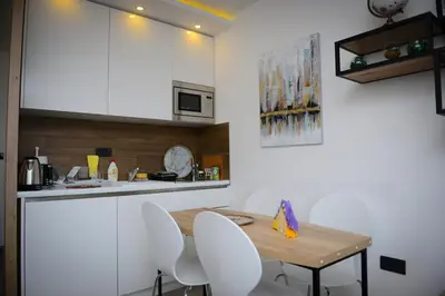 a kitchen with a wooden table and white chairs at Mips P86 Milmari Resort in Kopaonik