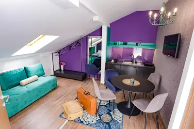 a living room with a blue couch and a table at Different Apartments in Niš