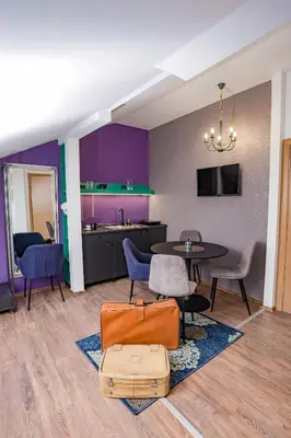 a living room with a table and chairs and purple walls at Different Apartments in Niš