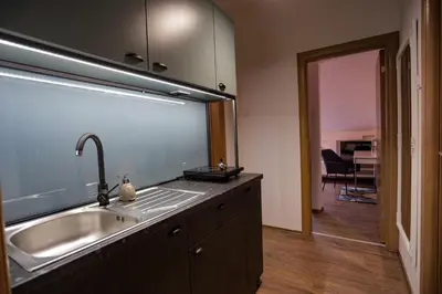 a kitchen with a sink and a large window at Different Apartments in Niš