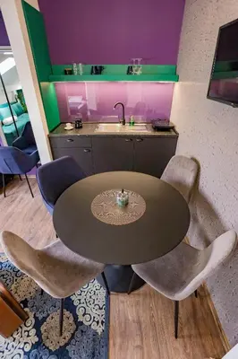 a kitchen with a table and chairs and a sink at Different Apartments in Niš