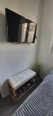 a bedroom with a tv on the wall next to a bed at Studio Milica in Vrnjačka Banja