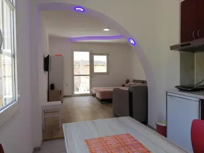 a living room with a room with an archway at Apartmani Ruj in Soko Banja
