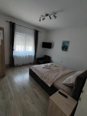 a bedroom with a bed and a chair in it at Apartmani Ruj in Soko Banja
