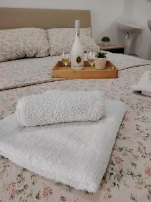a bed with two towels and two wine glasses on it at Apartmani Ruj in Soko Banja