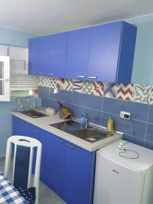 a blue kitchen with a sink and blue cabinets at Apartman Azzuro Vrnjačka Banja in Vrnjačka Banja