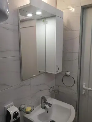 a bathroom with a white sink and a mirror at Apartman Azzuro Vrnjačka Banja in Vrnjačka Banja