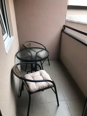 two chairs and a table in a room with a window at Sunce in Kruševac