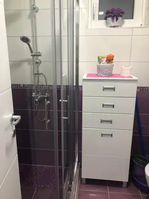 a bathroom with a shower and a white dresser at Sunce in Kruševac