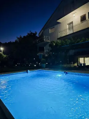 a swimming pool in front of a building at night at Domaćinstvo Trifunović in Pretrešnja