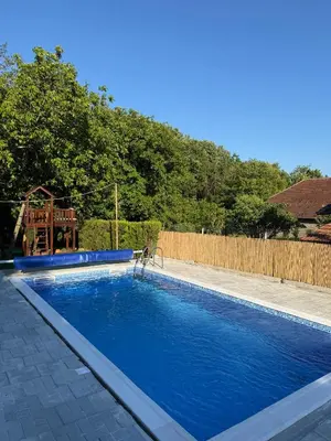a swimming pool in a yard next to a fence at Domaćinstvo Trifunović in Pretrešnja