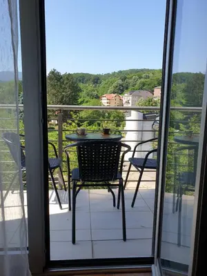 a table and chairs on a balcony with a view at Happy in Vrnjačka Banja