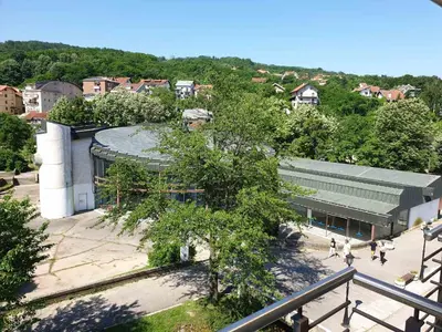 a building with people walking in front of it at Happy in Vrnjačka Banja