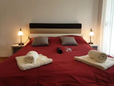 a bedroom with a red bed with towels on it at Happy in Vrnjačka Banja