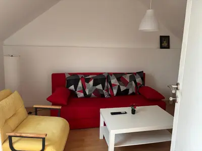 a living room with a red couch and a table at Banjica 2 in Soko Banja