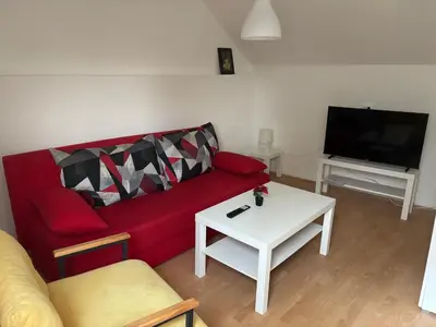a living room with a red couch and a tv at Banjica 2 in Soko Banja