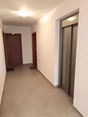 a corridor of an office building with doors and tile floors at Apartman Radmanovac 2 in Vrnjačka Banja