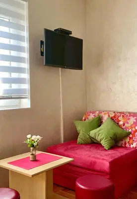 a living room with a red couch and a tv on the wall at Apartman Radmanovac 2 in Vrnjačka Banja