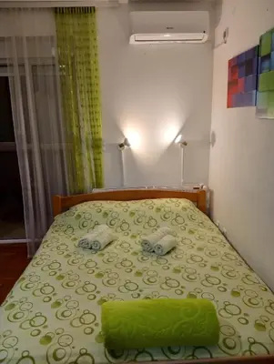 a bedroom with a bed with a green bedspread at Apartman Radmanovac 2 in Vrnjačka Banja
