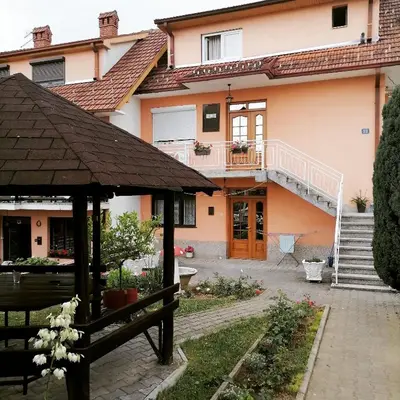 a house with a bench in front of it at Apartmani Arsic in Vrnjačka Banja