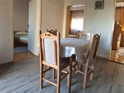 a table and chairs with a table and a bedroom at Apartmani Arsic in Vrnjačka Banja