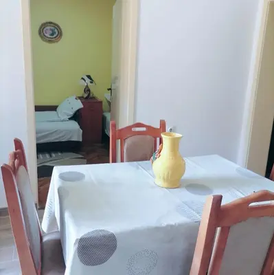 a yellow vase sitting on a table in a room at Apartmani Arsic in Vrnjačka Banja