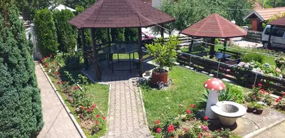 a garden with a gazebo and some flowers at Apartmani Arsic in Vrnjačka Banja