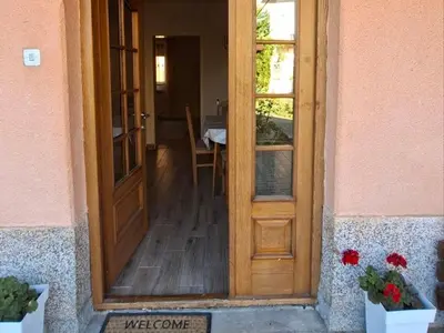 a wooden door of a house with a table at Apartmani Arsic in Vrnjačka Banja